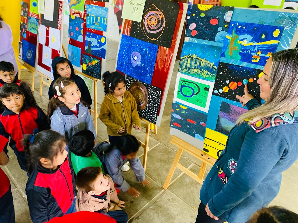 Profesora mostrando arte visual a alumnos